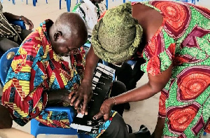 EC officials training the visually impaired on how to use the tactile jacket to vote