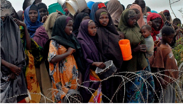 Internally-displaced Somalis wait for food at a distribution point  at a refugee camp