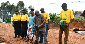 A senior Entomologist at the Ministry of Health demonstrates larviciding to the Village Health