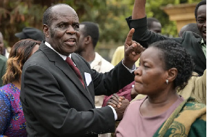 Gilbert Deya (C), celebrates outside the court with his followers after he was acquitted