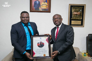 Mr. Oppong Nkrumah [R] receiving a citation from Kelly Nii Lartey [L]