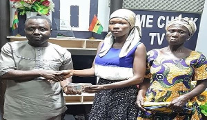 Alice Bonye receiving the donation from a staff of Crime Check TV