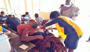 A Chief receiving his jab of the coronavirus vaccine