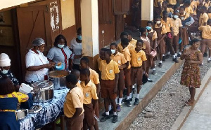 School children line up for school feeding meals