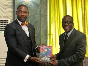 Bernard Okoe-Boye presenting his book to Alban Bagbin