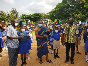 Appianyinasehene (in cloth) poses with pupils and teachers of one of the beneficiary schools