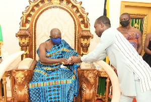 Otumfuo Osei Tutu II, Asantehene receiving the commemorative gold coin